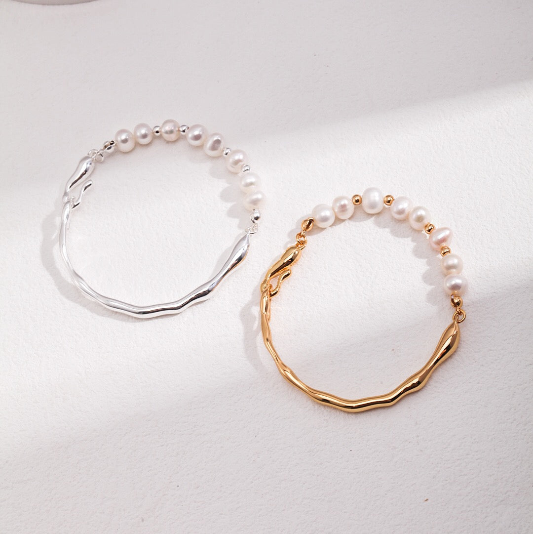 Two Freshwater Pearl Bangle Bracelets, one with gold vermeil and the other with silver, displayed on a white surface.