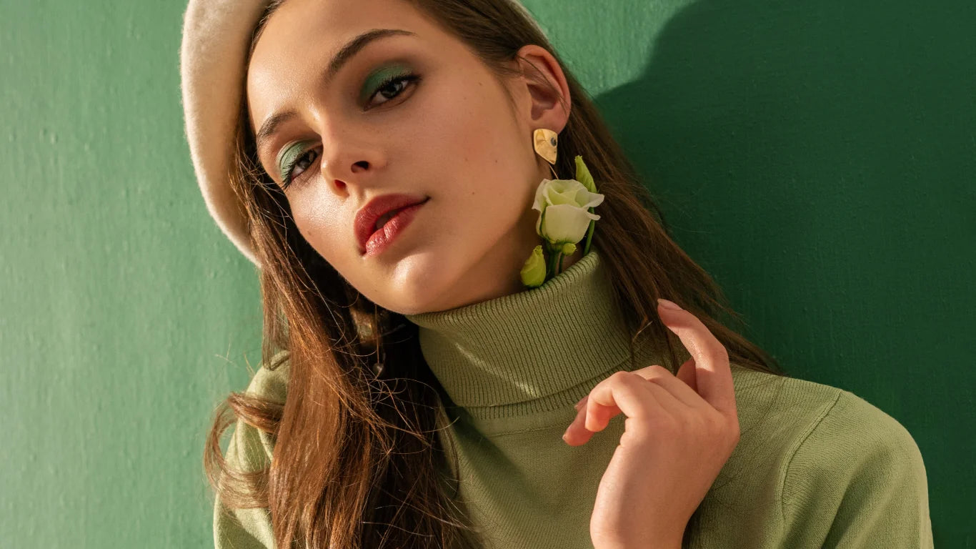 Woman wearing a green turtleneck sweater against a green background